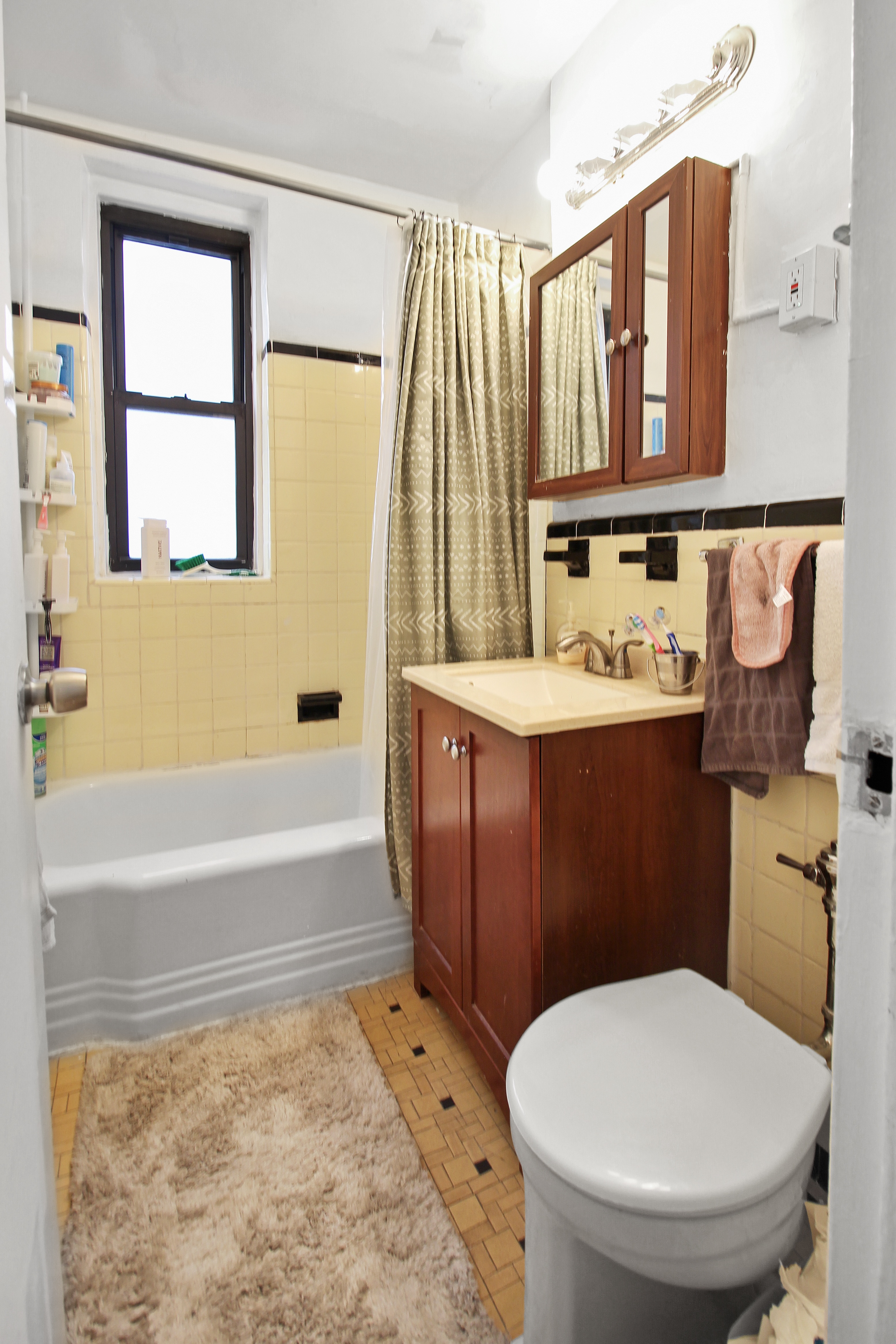 315 East 56th Street, Unit 5F Manhattan, NY 10022 - Photo 5 of 9 a bathroom with a sink a toilet and bathtub