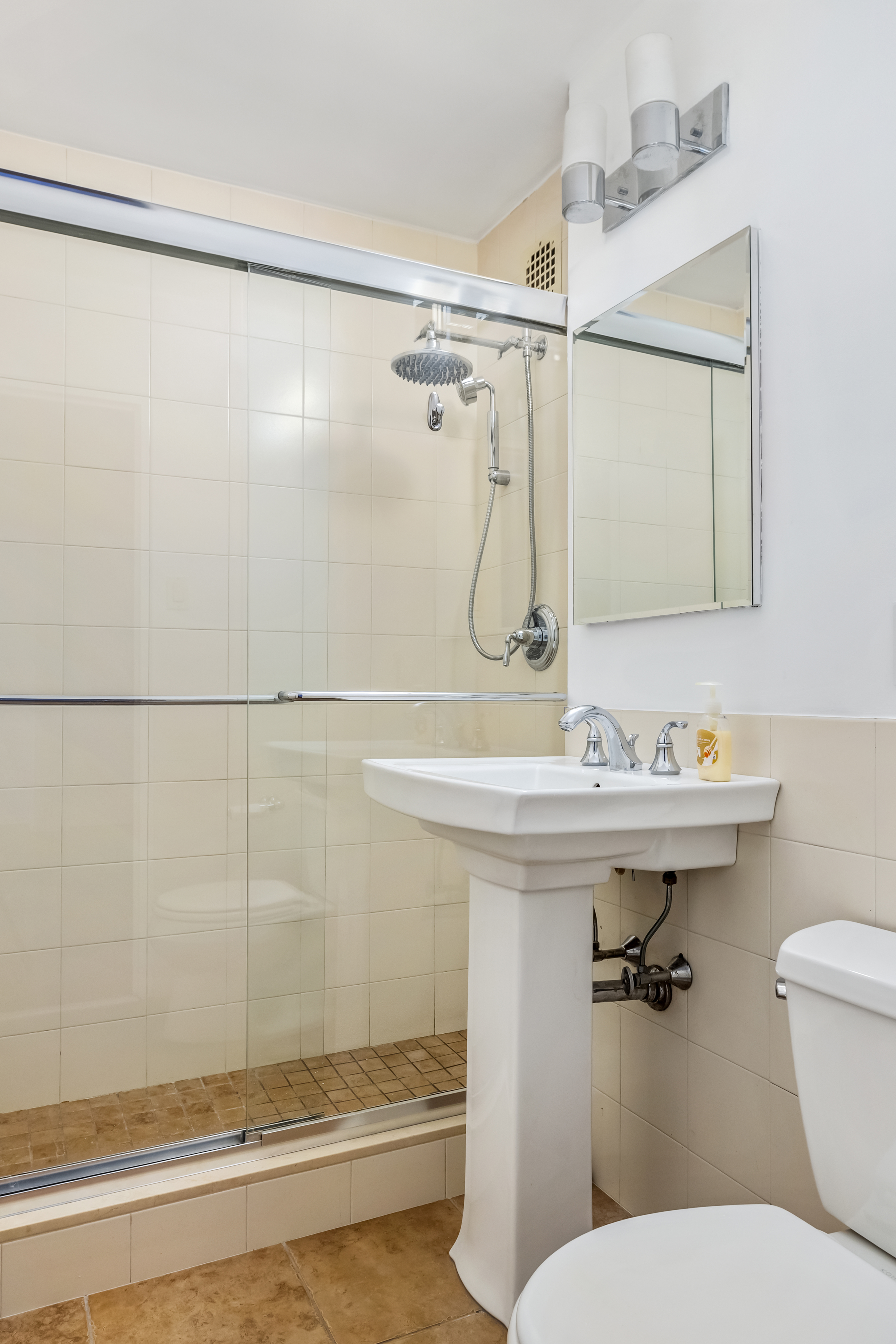 233 East 69th Street, Unit 2C Manhattan, NY 10021 - Photo 3 of 10 a bathroom with a sink toilet and shower