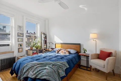 a bedroom with a bed a lamp and a window