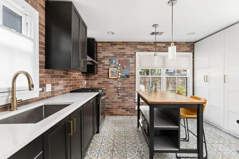 a kitchen with stainless steel appliances a sink a stove and a wooden floors