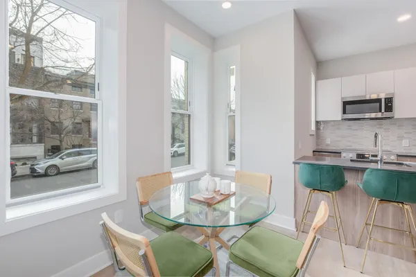 a view of a dining room with furniture wooden floor and a kitchen