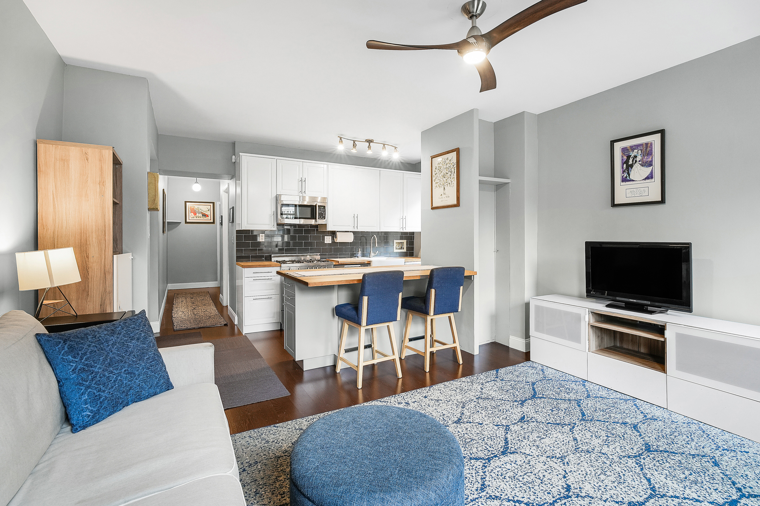 855 West End Avenue, Unit 4B Manhattan, NY 10025 - Photo 3 of 13 a living room with stainless steel appliances furniture and a flat screen tv
