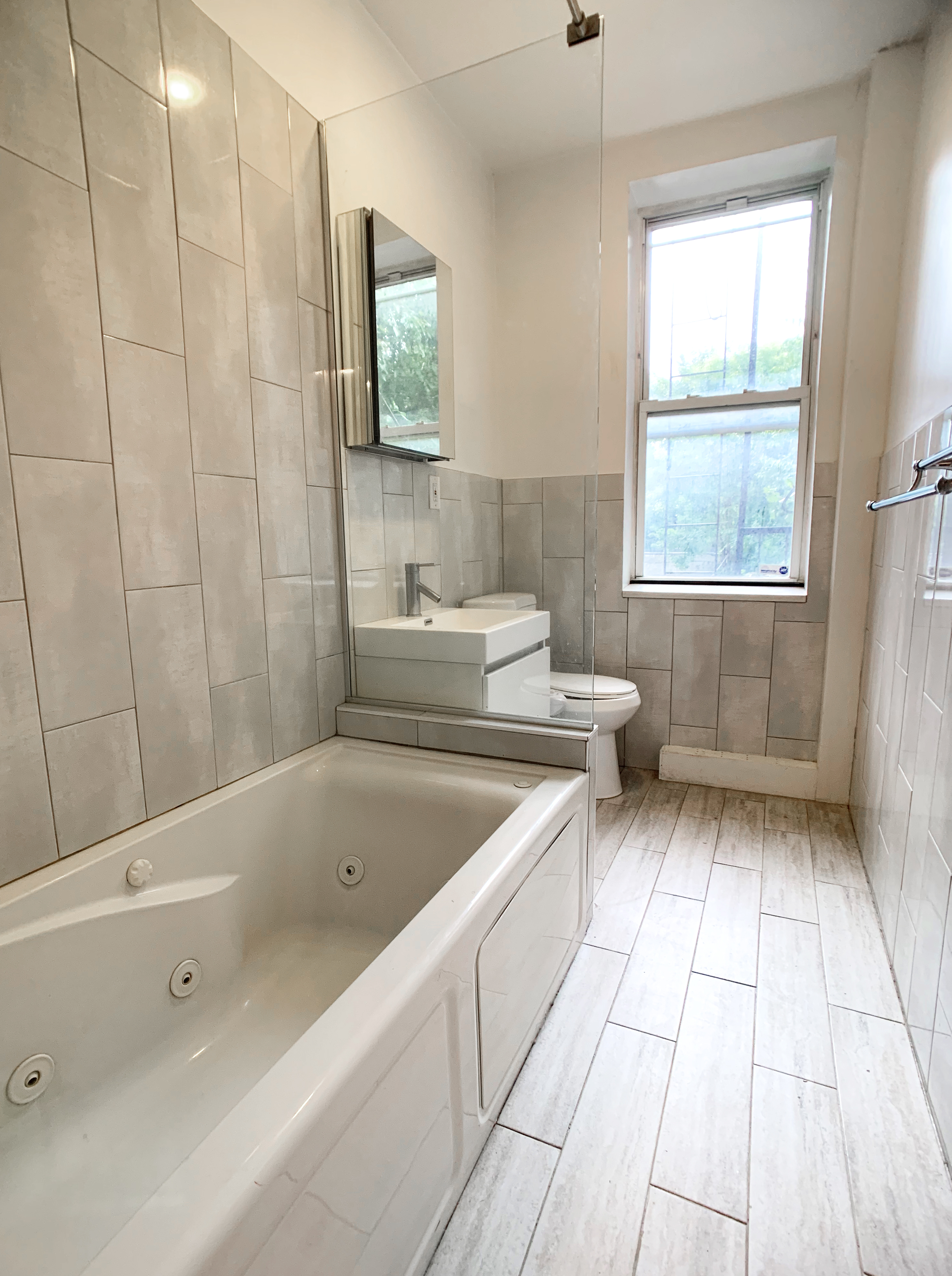 293 Tompkins Avenue, Unit 2 Brooklyn, NY 11221 - Photo 9 of 11 a bathroom with a sink and a bathtub