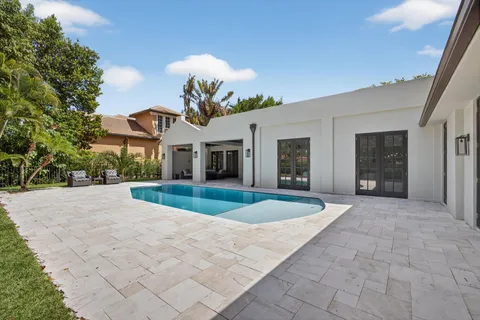a view of a white house with a yard and potted plants