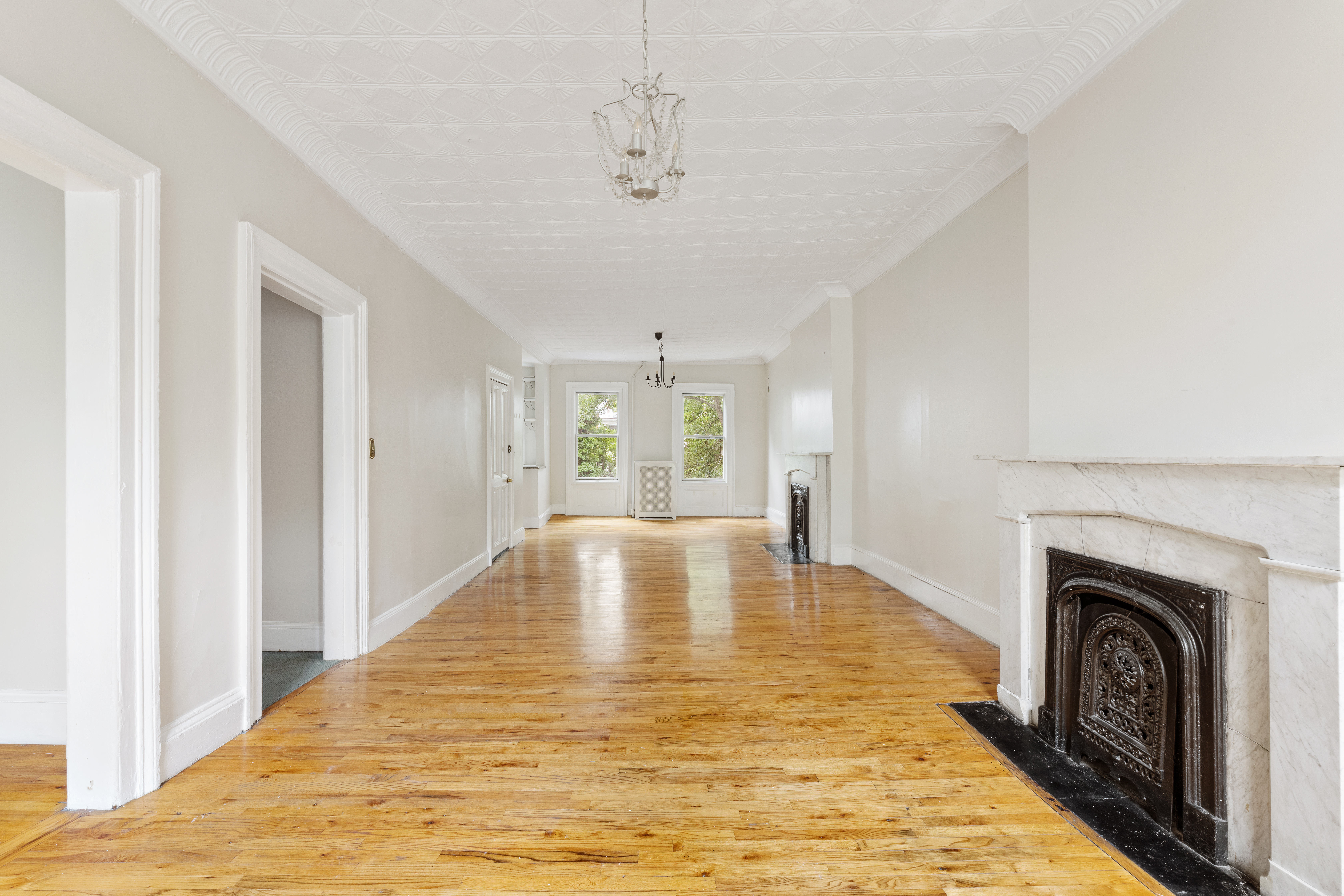 390 Pacific Street, Unit 2 Brooklyn, NY 11217 - Photo 6 of 10 a view of empty room with wooden floor and fireplace