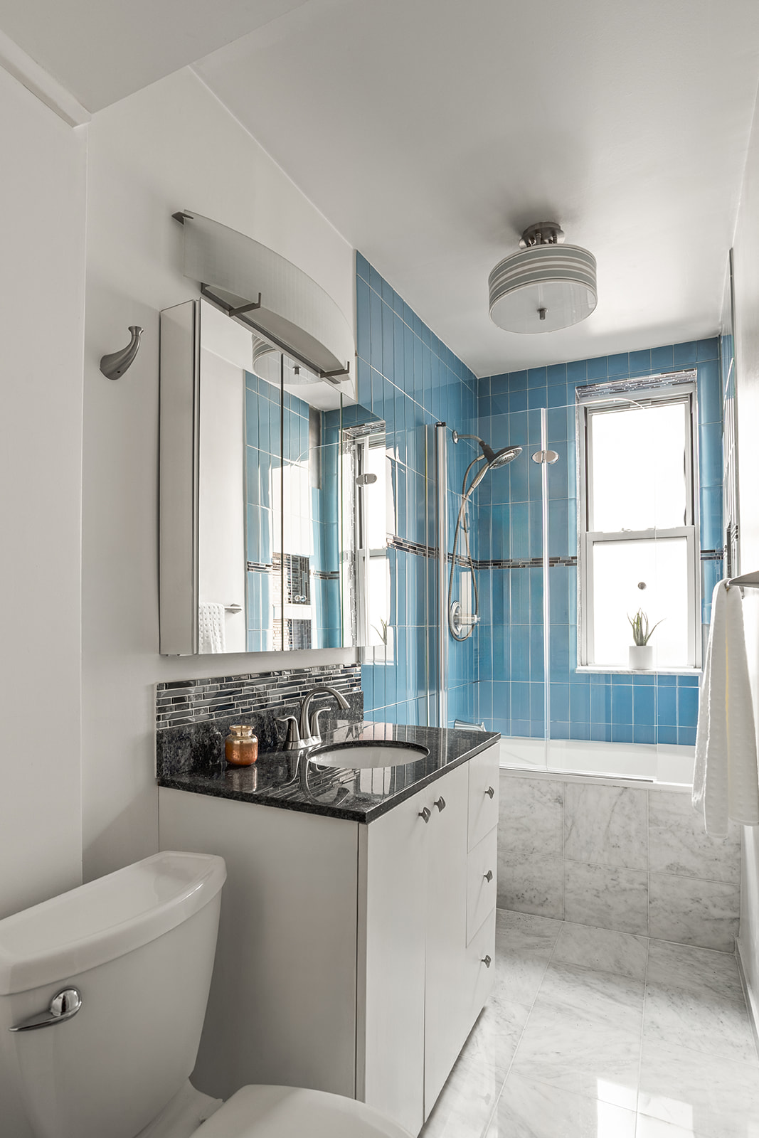 210 East 17th Street, Unit 5C Manhattan, NY 10003 - Photo 6 of 18 a bathroom with a granite countertop sink a toilet and mirror