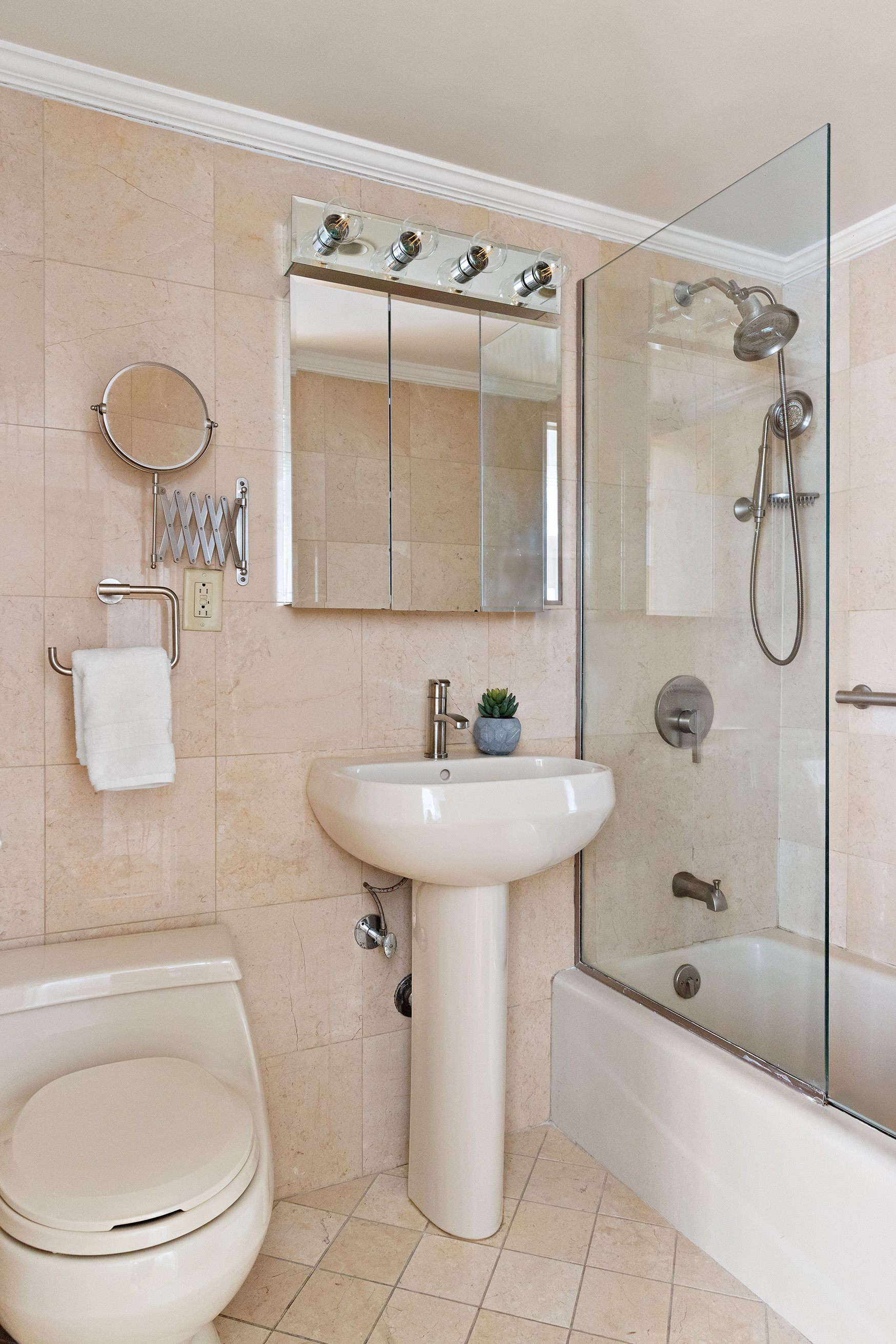 330 East 49th Street, Unit 9C Manhattan, NY 10017 - Photo 8 of 13 a bathroom with a sink a toilet and shower