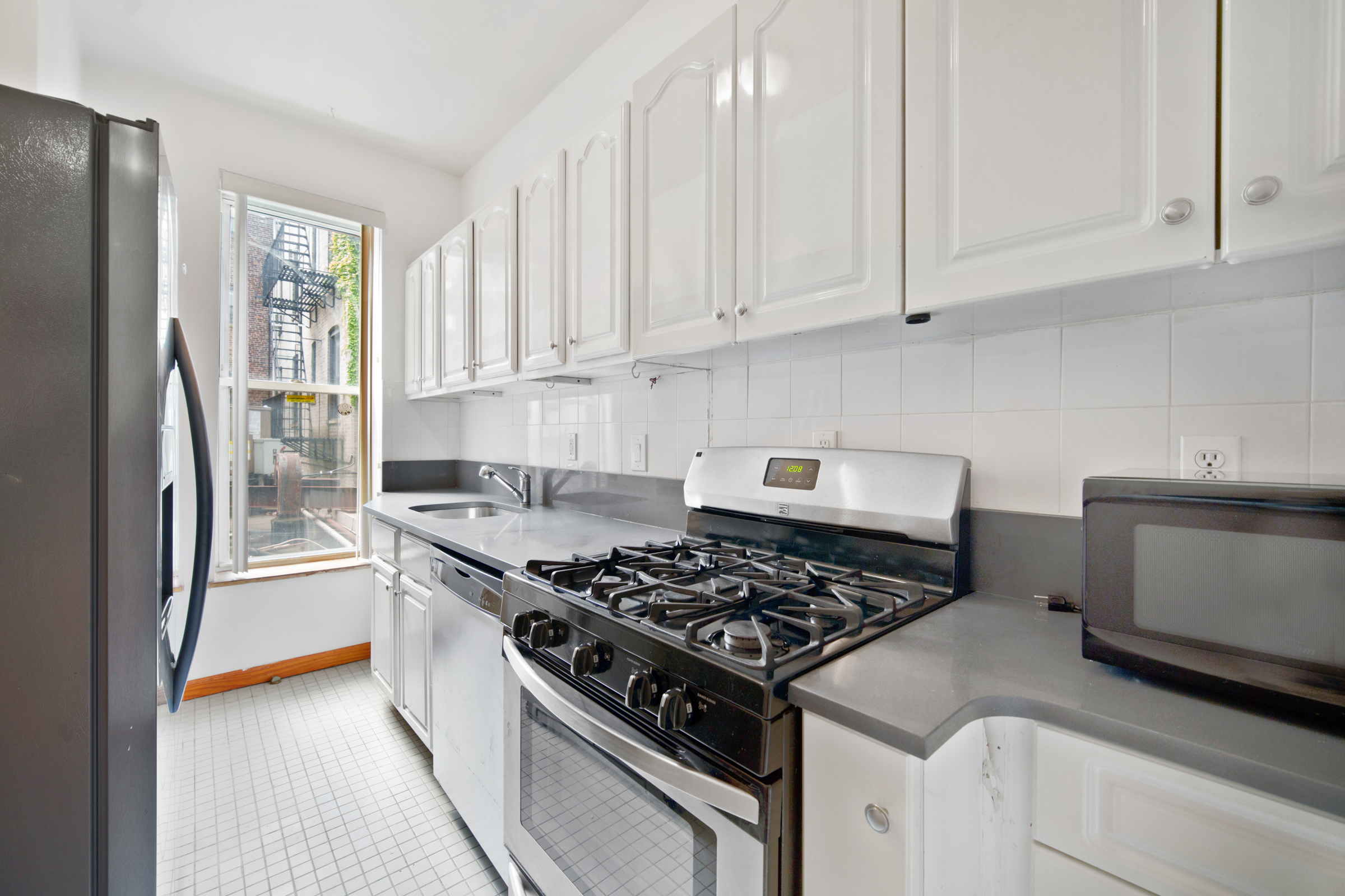 614 Eastern Parkway, Unit 2 Brooklyn, NY 11225 - Photo 5 of 6 a kitchen with stainless steel appliances granite countertop a stove and a refrigerator