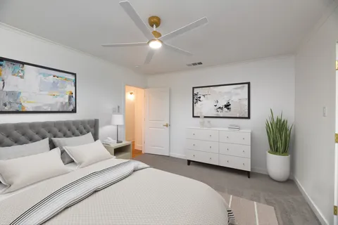 a bedroom with a large bed and a chandelier