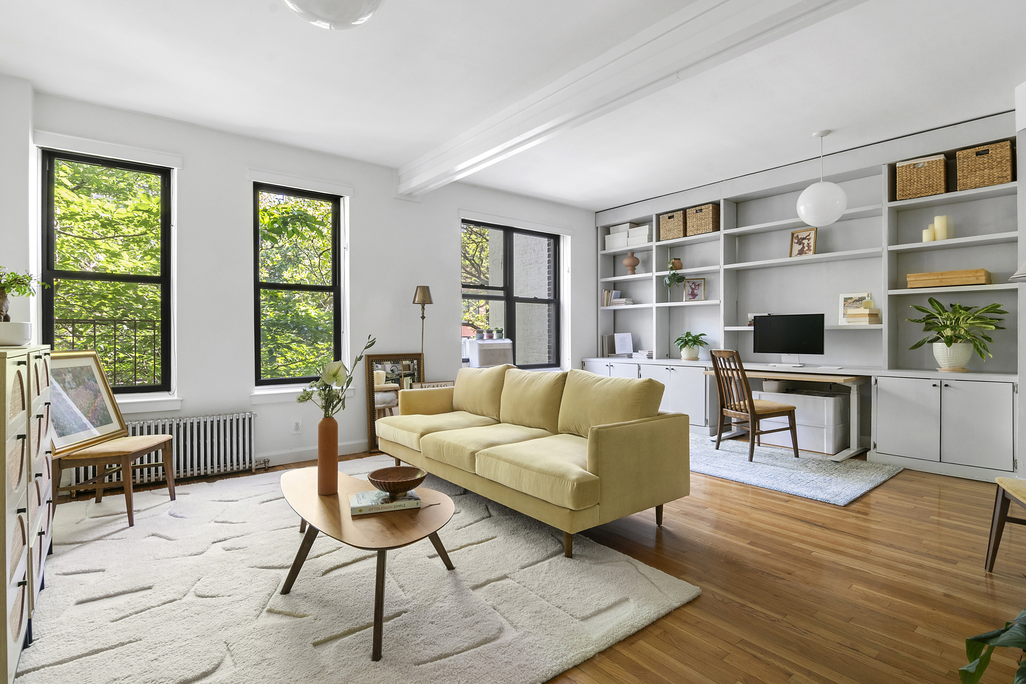 a living room with furniture a flat screen tv and windows