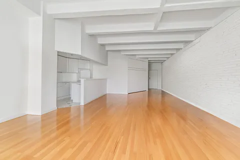 a view of empty room with wooden floor and cabinet