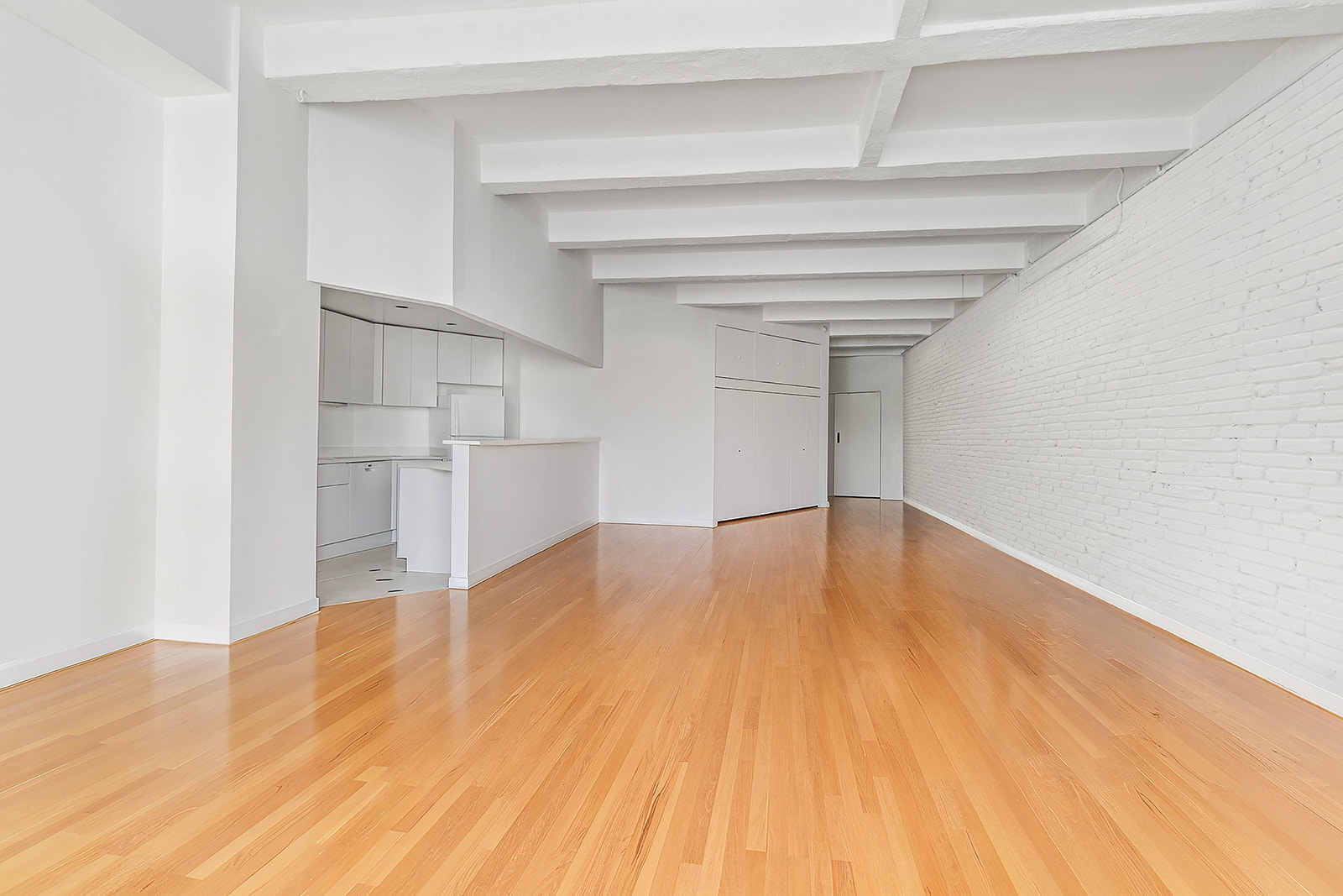 321 West 13th Street, Unit 3A Manhattan, NY 10014 - Photo 6 of 12 a view of empty room with wooden floor and cabinet