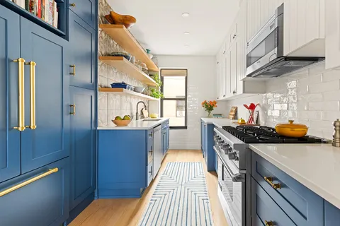 a kitchen with stainless steel appliances granite countertop a lot of cabinets