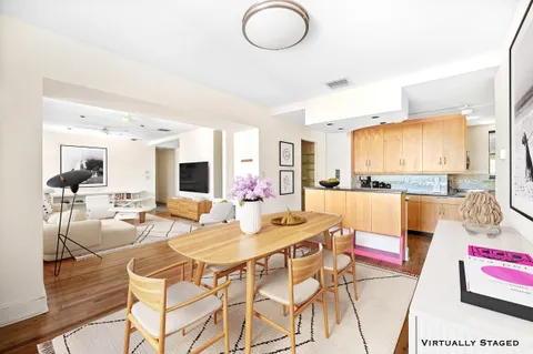 a view of a dining room and livingroom with furniture wooden floor and a rug