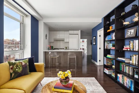 a living room with furniture and a book shelf