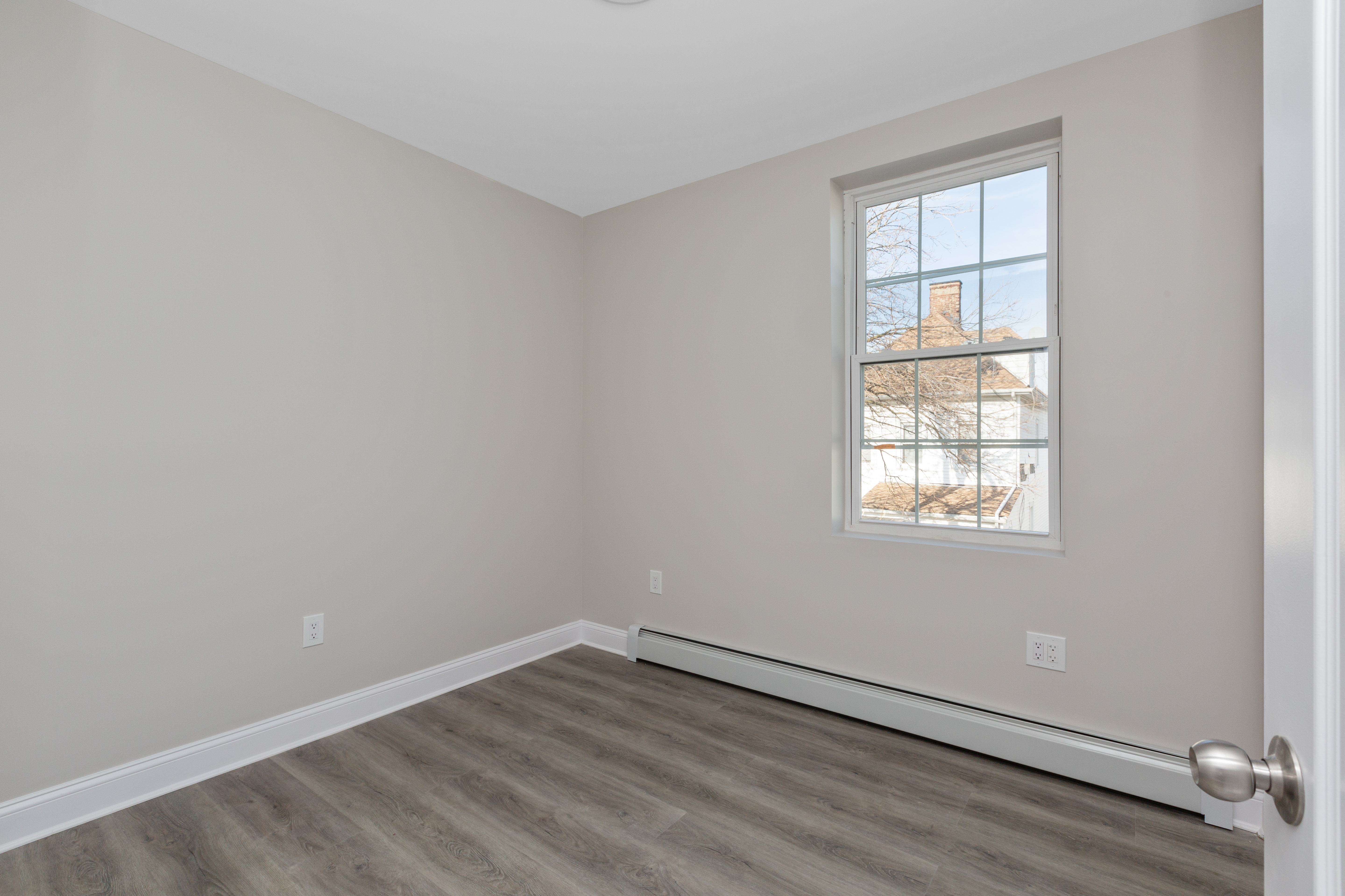 143-10 Shore Avenue Queens, NY 11435 - Photo 7 of 30 an empty room with wooden floor and windows