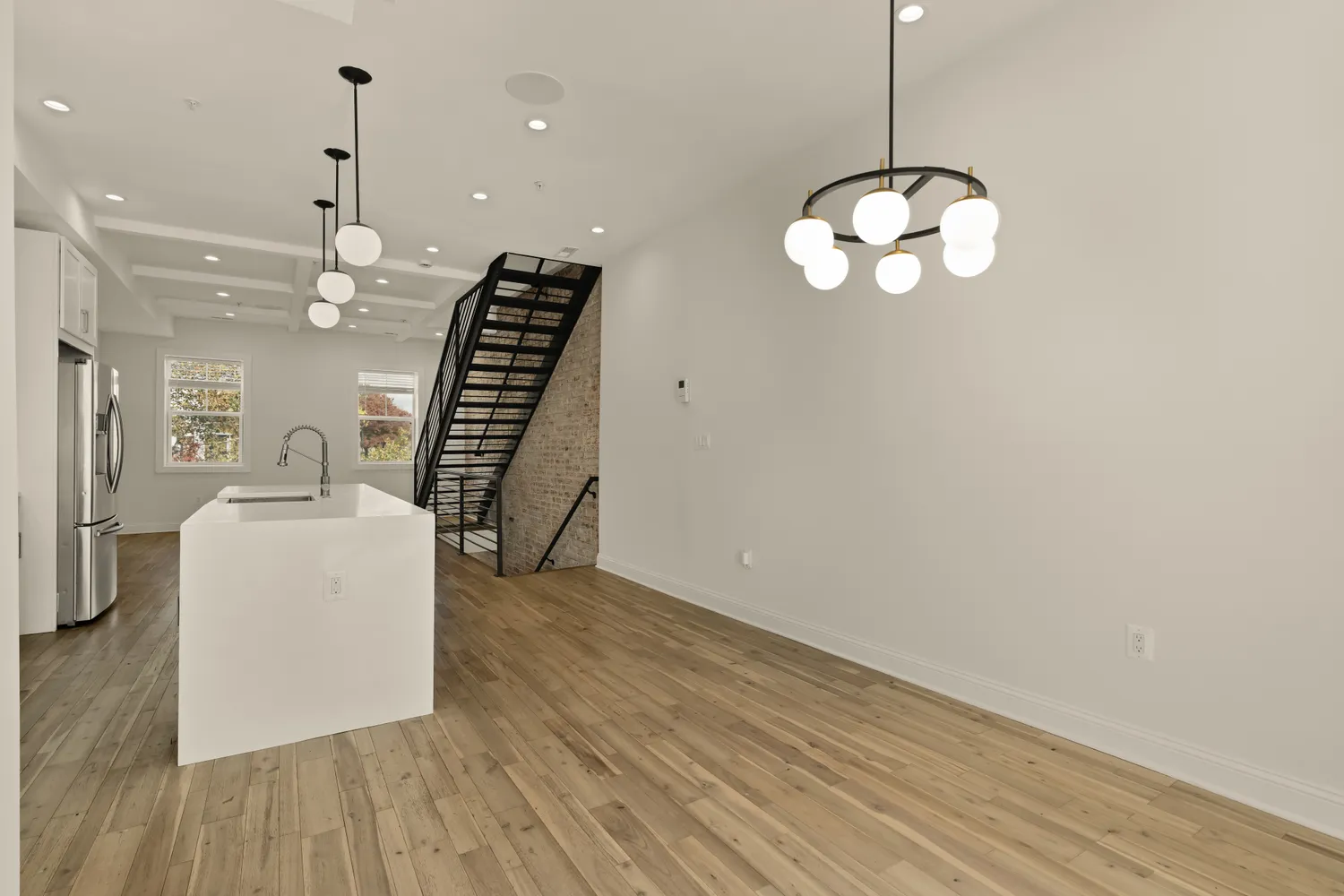 a view of a room with wooden floor and stainless steel appliances