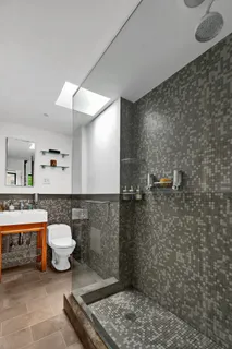 a bathroom with a toilet a sink and mirror