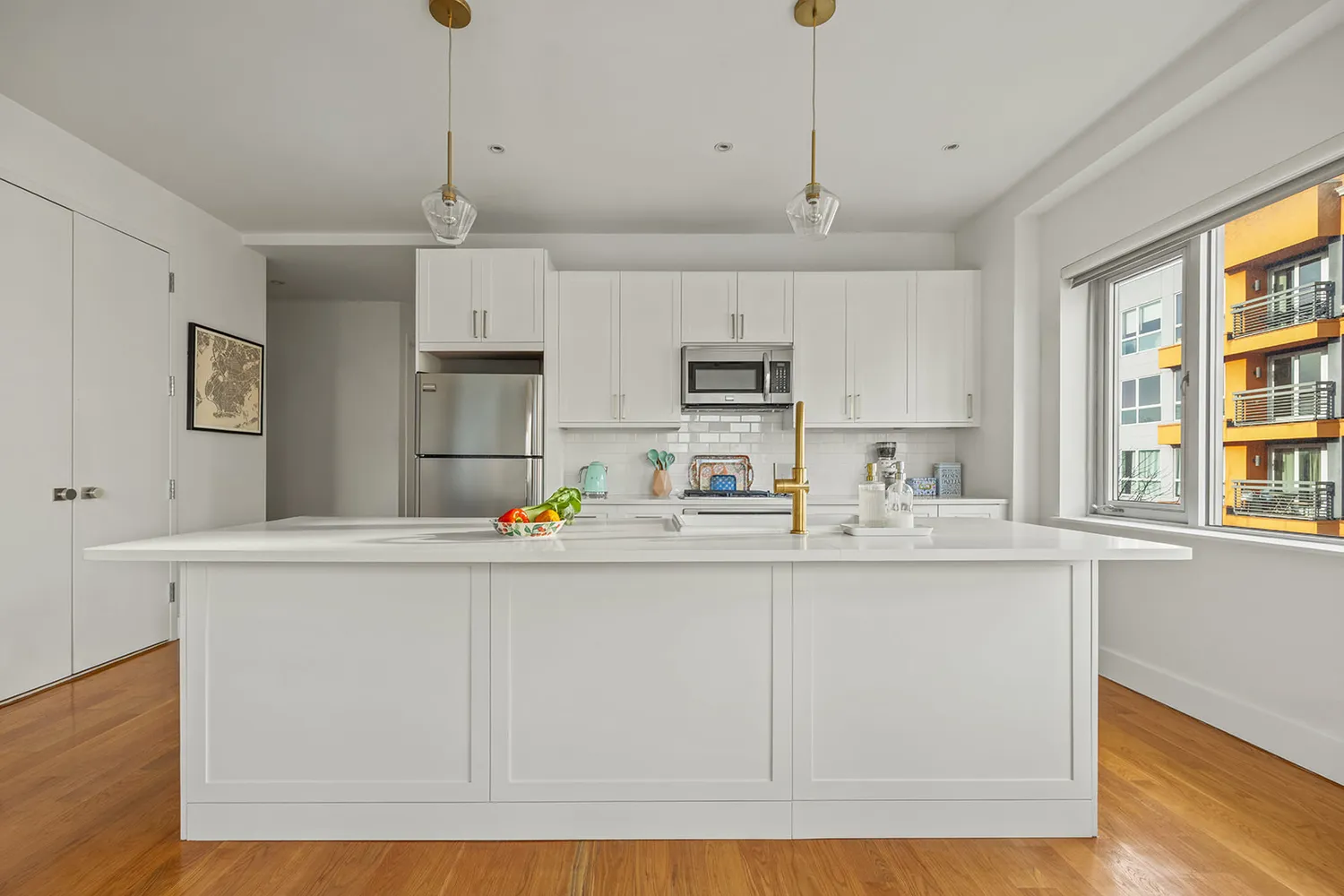 a kitchen with stainless steel appliances granite countertop a sink a stove a refrigerator and white cabinets with wooden floor