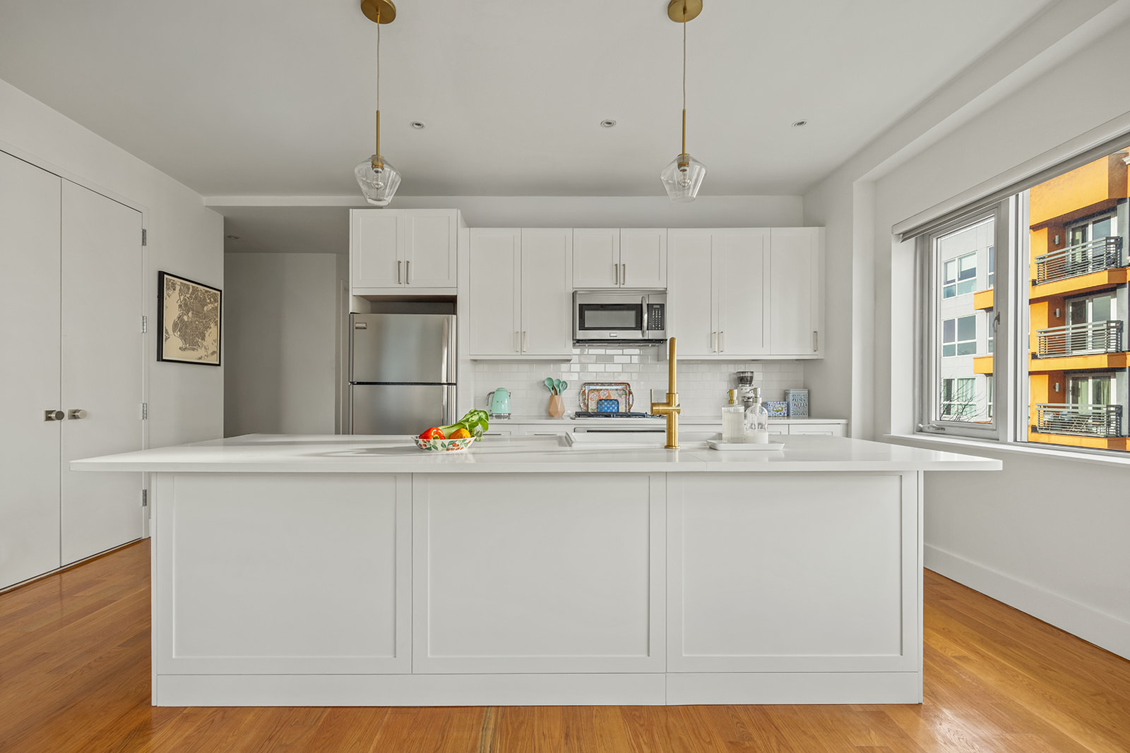 432 Grand Street, Unit 402 Brooklyn, NY 11211 - Photo 2 of 12 a kitchen with stainless steel appliances granite countertop a sink a stove a refrigerator and white cabinets with wooden floor