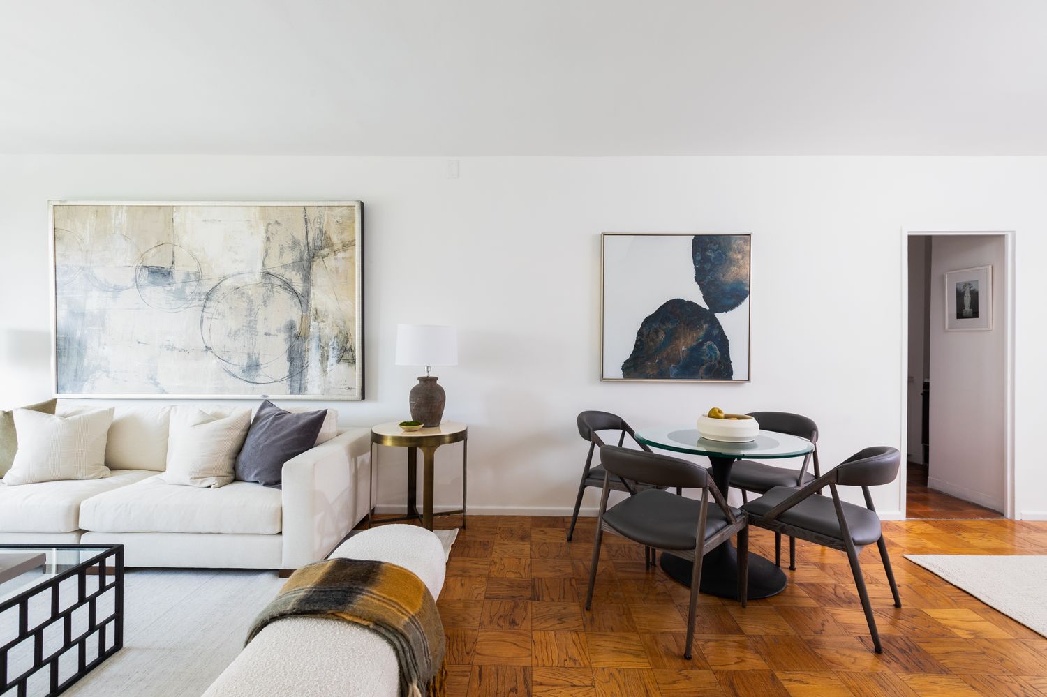 a living room with couches a coffee table and four couches with wooden floor