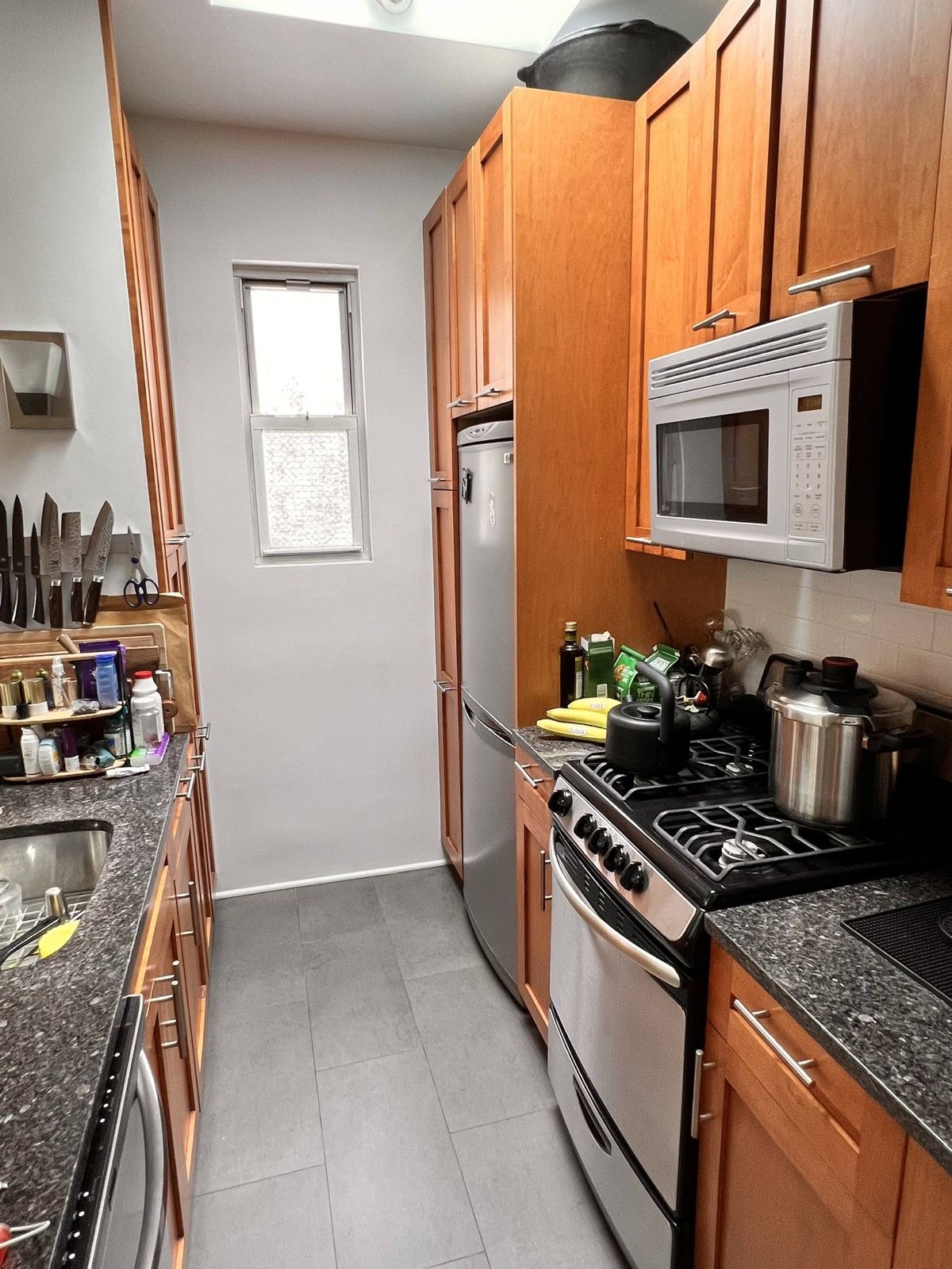 73 Perry Street, Unit 5 Manhattan, NY 10014 - Photo 6 of 10 a kitchen with stainless steel appliances granite countertop a stove and a refrigerator