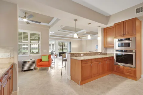 a large kitchen with stainless steel appliances kitchen island granite countertop a large kitchen island a stove and a refrigerator
