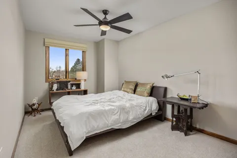 a bedroom with a bed table and chair