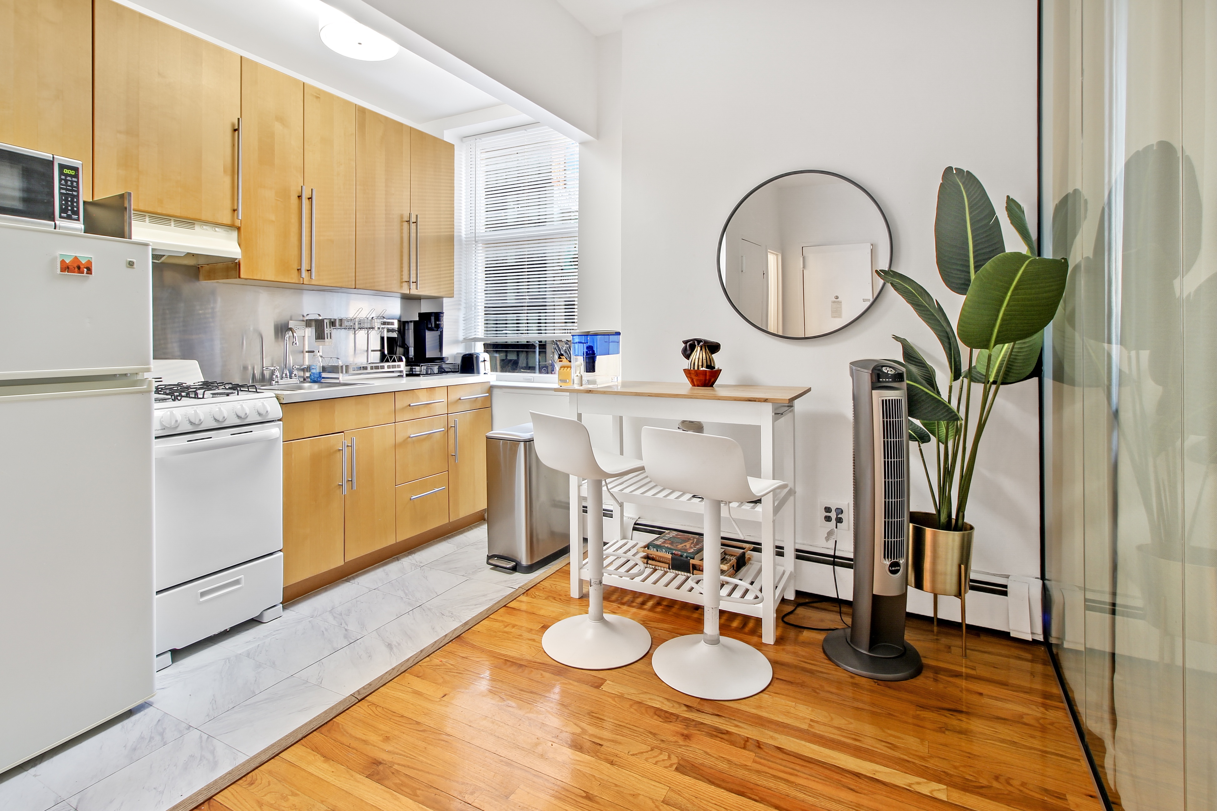 621 2nd Avenue, Unit 2 Manhattan, NY 10016 - Photo 5 of 8 a kitchen with sink refrigerator dining table and chairs