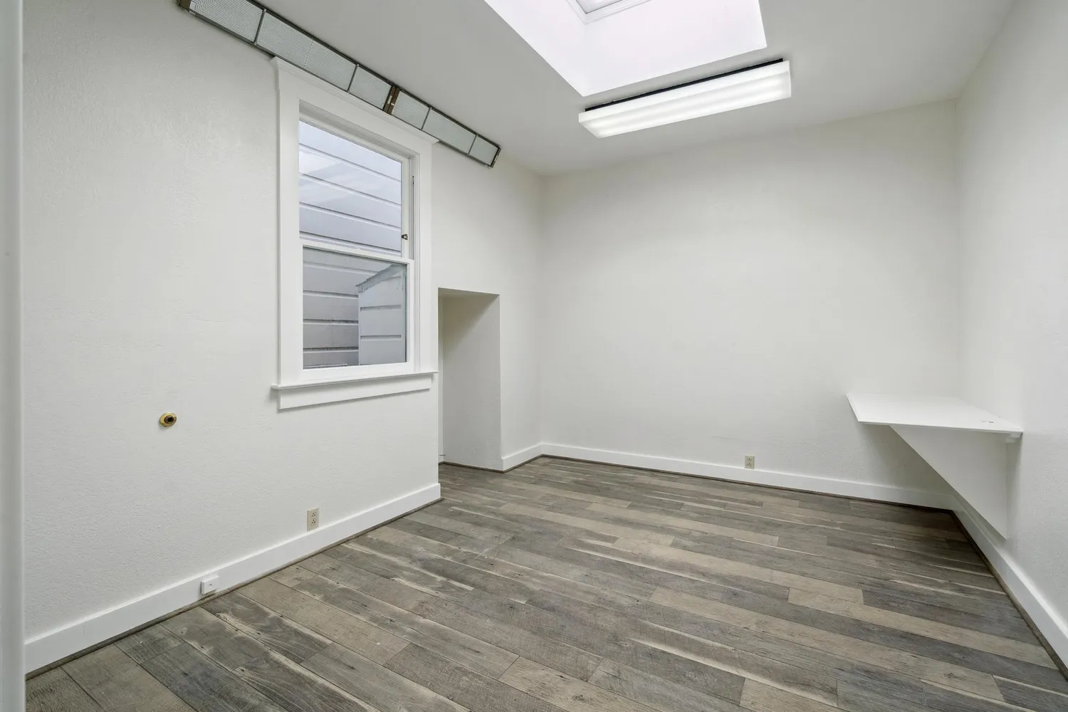 a view of an empty room and wooden floor