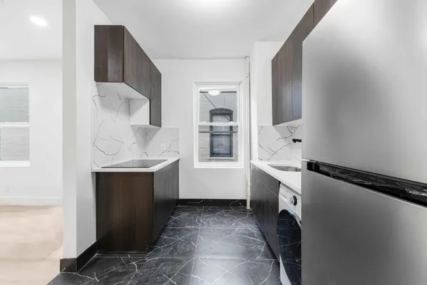 a room with a sink and a refrigerator