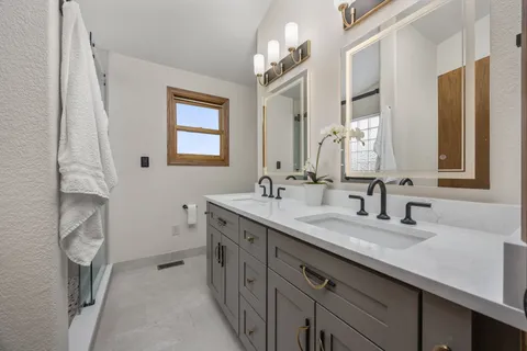 a bathroom with a double vanity sink and a mirror