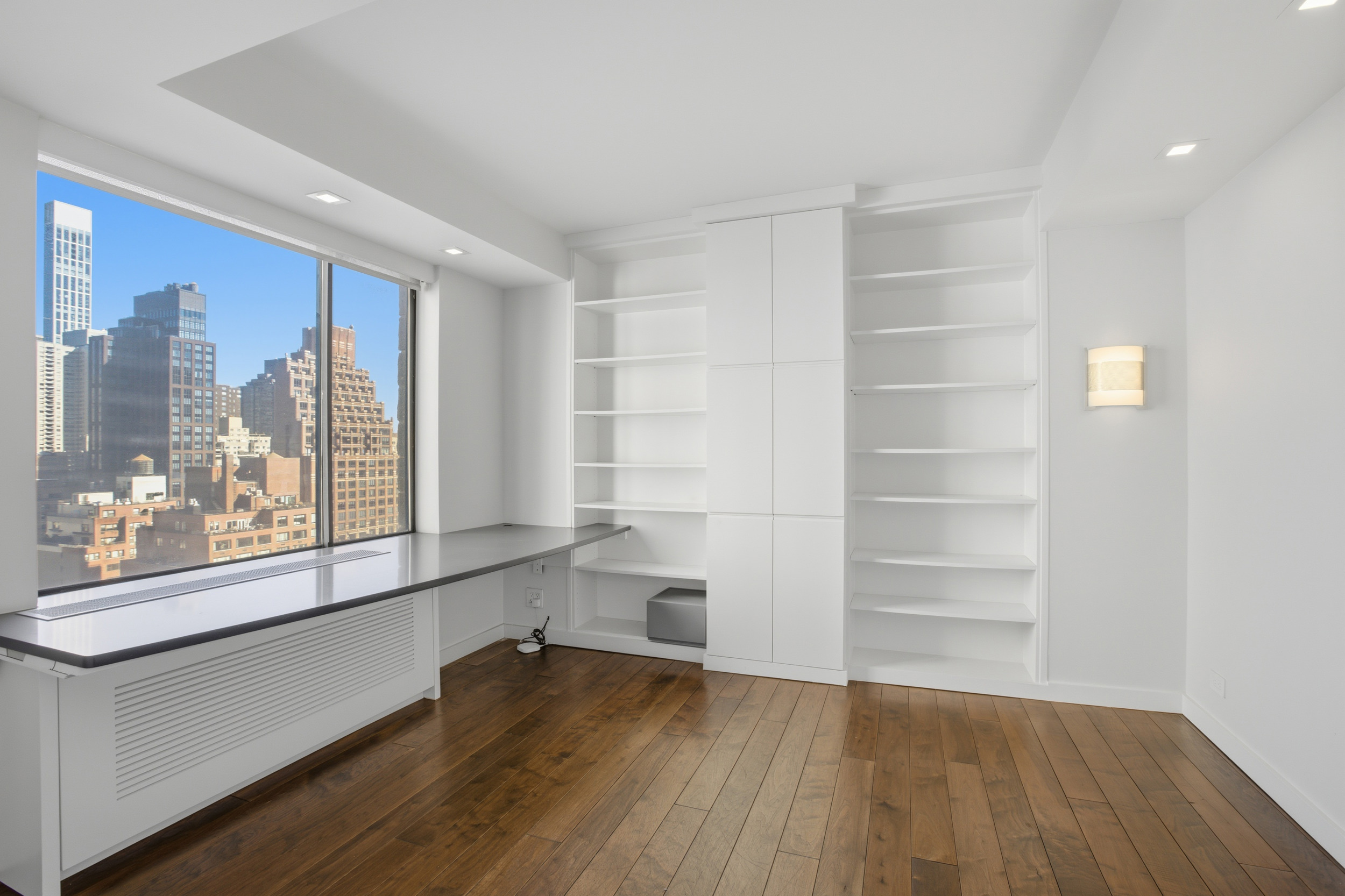 309 East 49th Street, Unit 21A Manhattan, NY 10017 - Photo 7 of 18 a view of empty room with wooden floor and fan