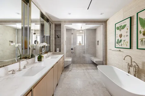a bathroom with double vanity sinks a large mirror and a shower