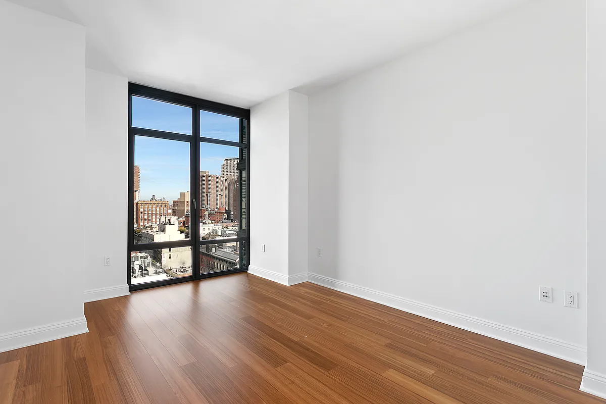 57 Reade Street, Unit 14C Manhattan, NY 10007 - Photo 10 of 16 an empty room with wooden floor and windows