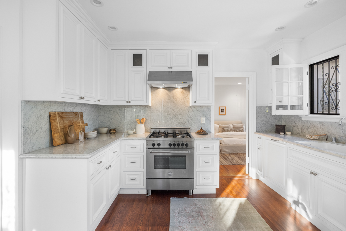 926 Burnside Avenue Los Angeles, CA 90036 - Photo 19 of 71 a kitchen with stainless steel appliances granite countertop a stove and white cabinets