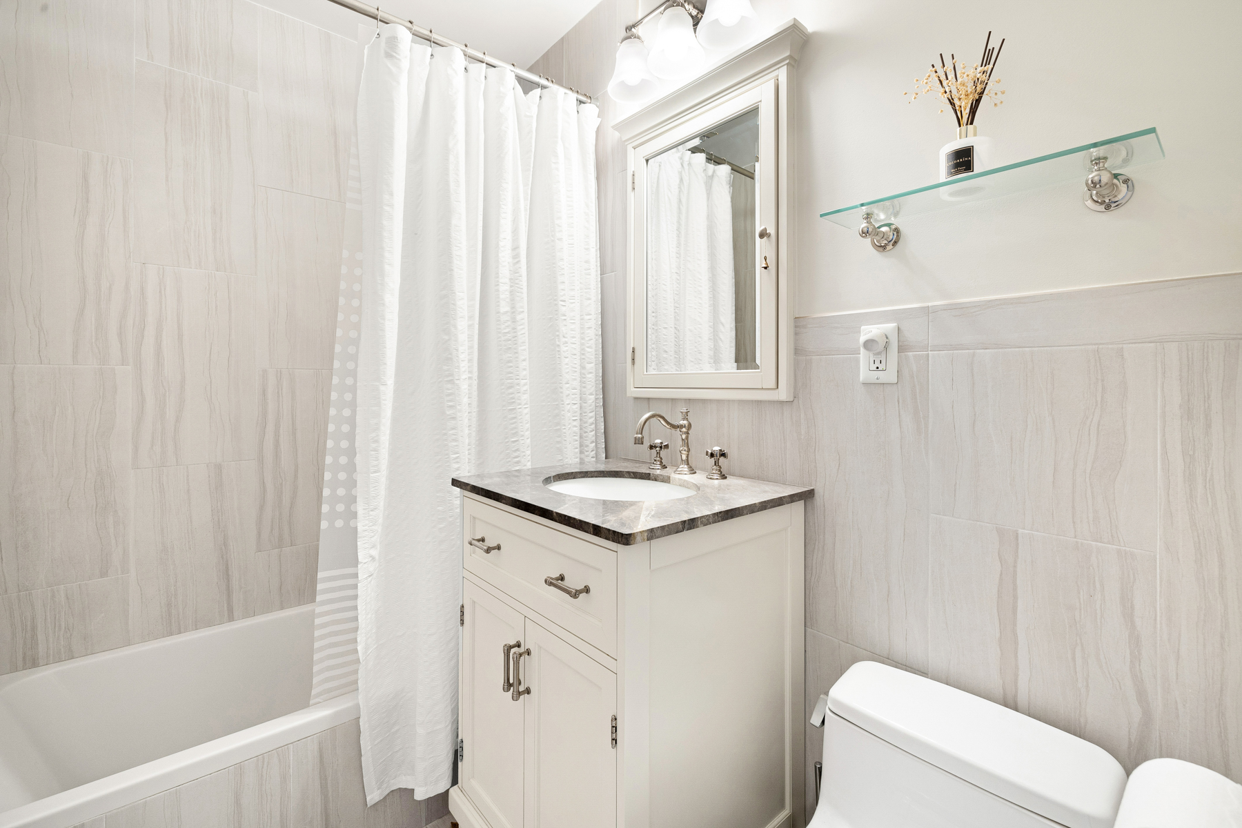555 Main Street, Unit 1002 Manhattan, NY 10044 - Photo 8 of 14 a bathroom with a granite countertop sink and a mirror