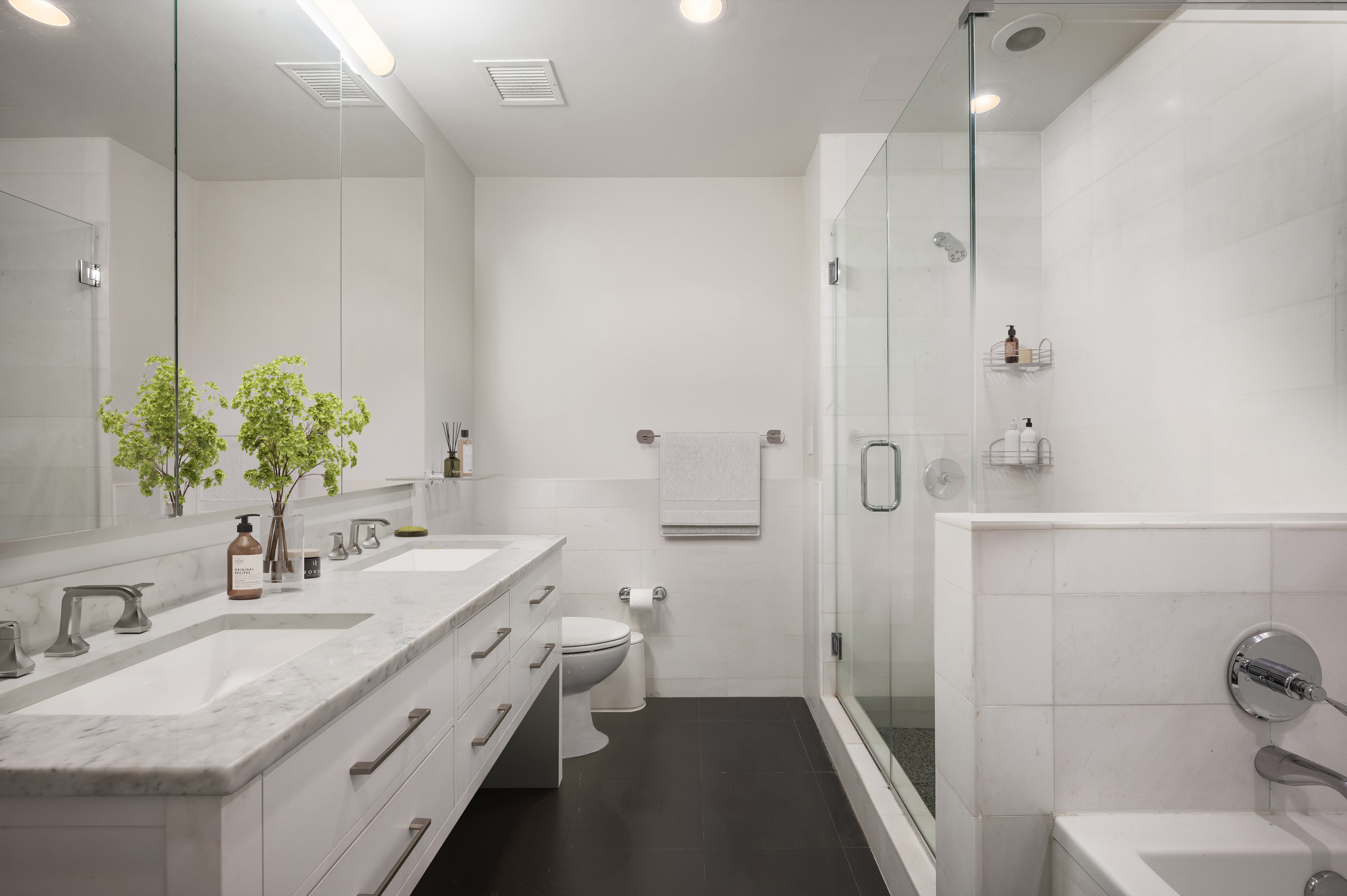 125 West 22nd Street, Unit 8B Manhattan, NY 10011 - Photo 5 of 10 a bathroom with a double vanity sink toilet and shower