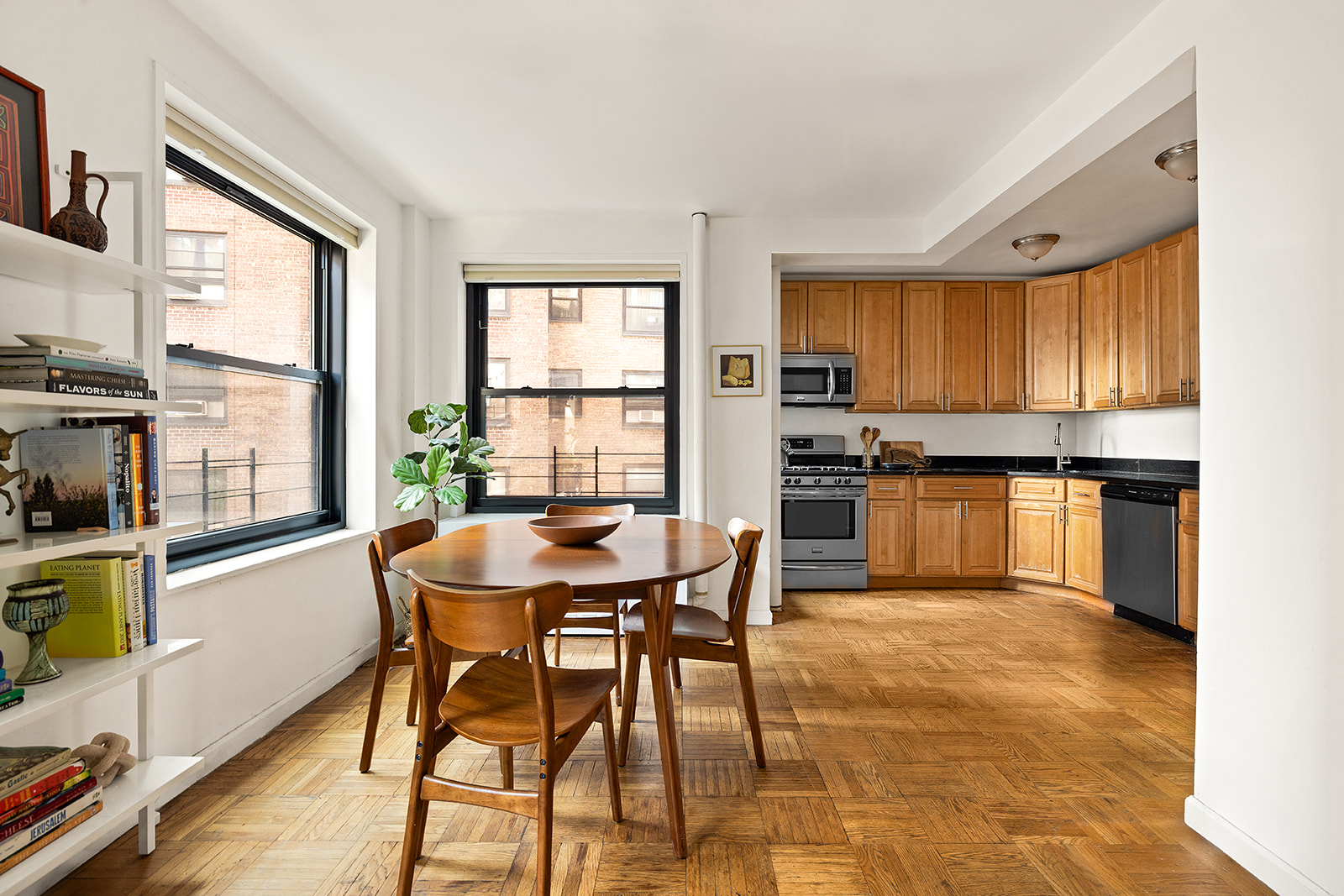 201 Clinton Avenue, Unit 6F Brooklyn, NY 11205 - Photo 2 of 7 a kitchen with stainless steel appliances granite countertop a stove top oven a sink a dining table and chairs with wooden floor