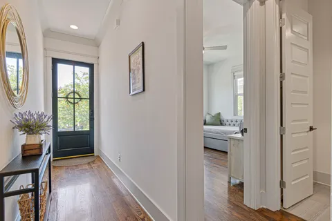 a view of a hallway with wooden floor and windows