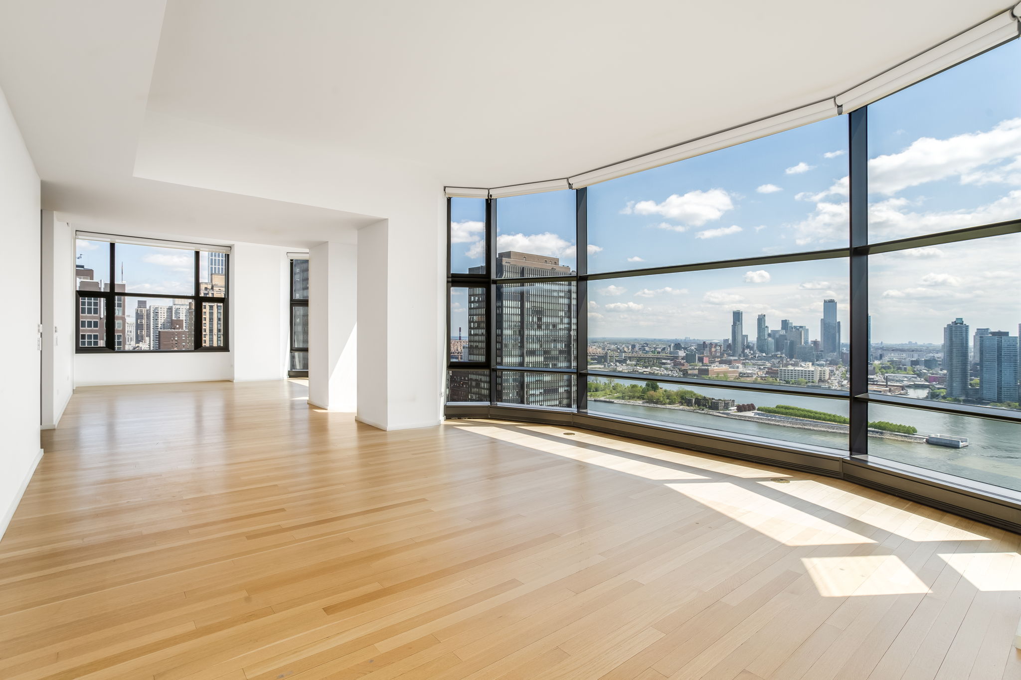 50 United Nations Plaza, Unit 26B Manhattan, NY 10017 - Photo 2 of 25 an empty room with wooden floor and windows