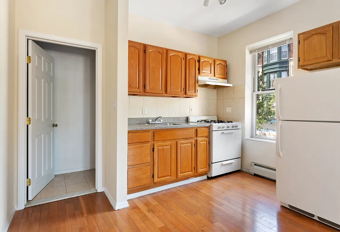 1402 Cortelyou Road, Unit 4 Brooklyn, NY 11226 - Photo 2 of 5 a kitchen with white cabinets and white appliances