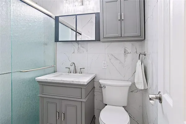 a bathroom with a toilet sink and cabinets