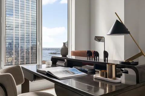 a view of a workspace with furniture and window