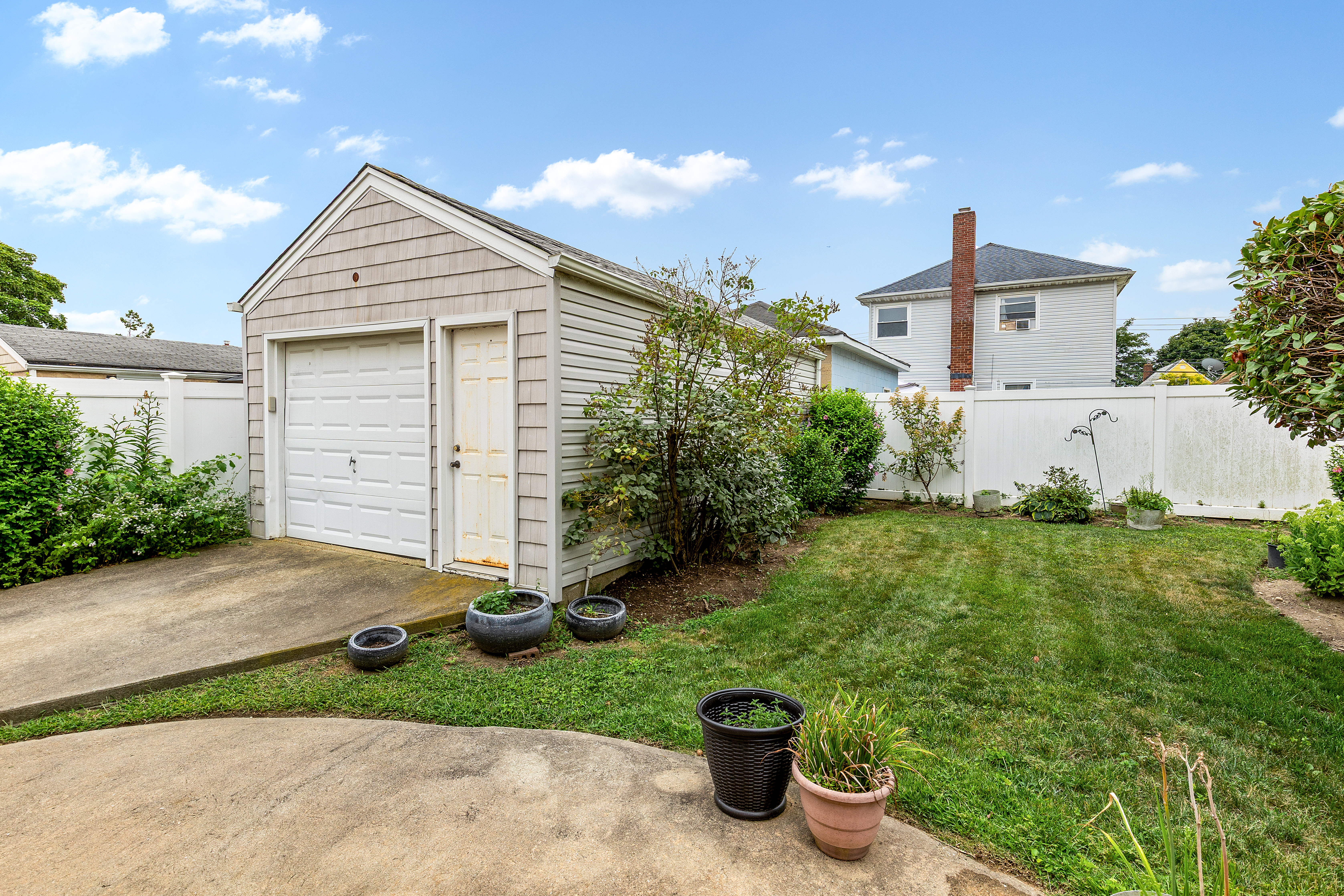 241-12 148th Avenue Queens, NY 11422 - Photo 13 of 15 a view of a house with a small yard and a garage