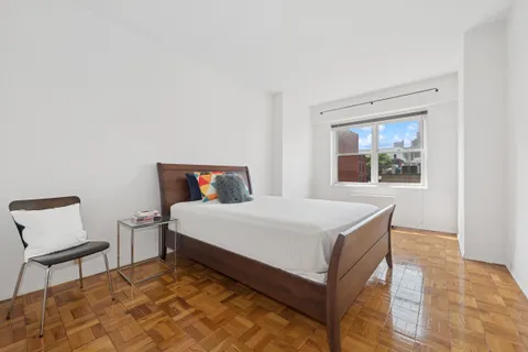 a bedroom with a bed and a chair