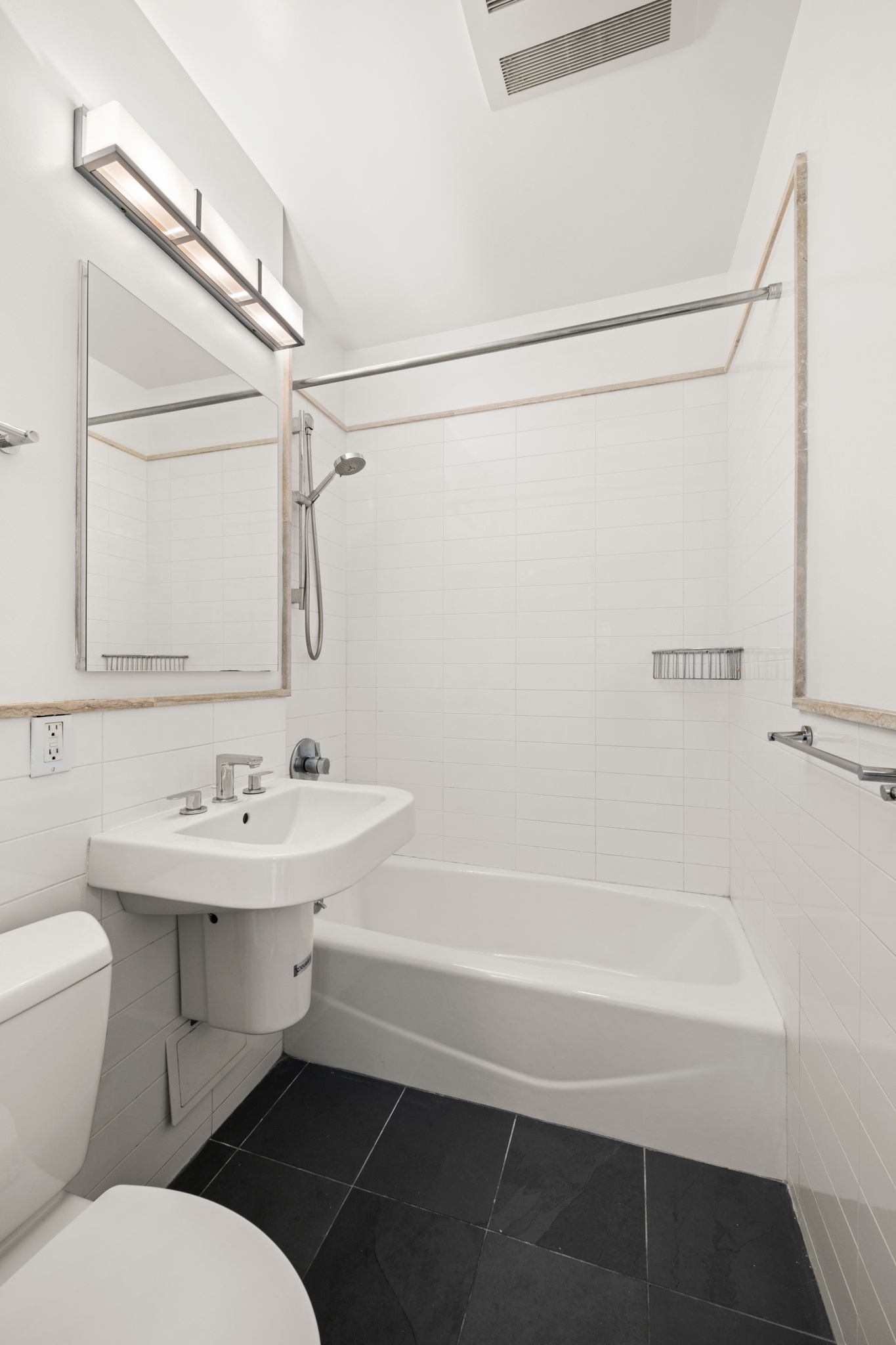 354 West 23rd Street, Unit 4A Manhattan, NY 10011 - Photo 6 of 7 a bathroom with a sink a toilet a mirror and shower