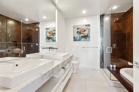 a spacious bathroom with a double vanity sink a mirror and a bathtub