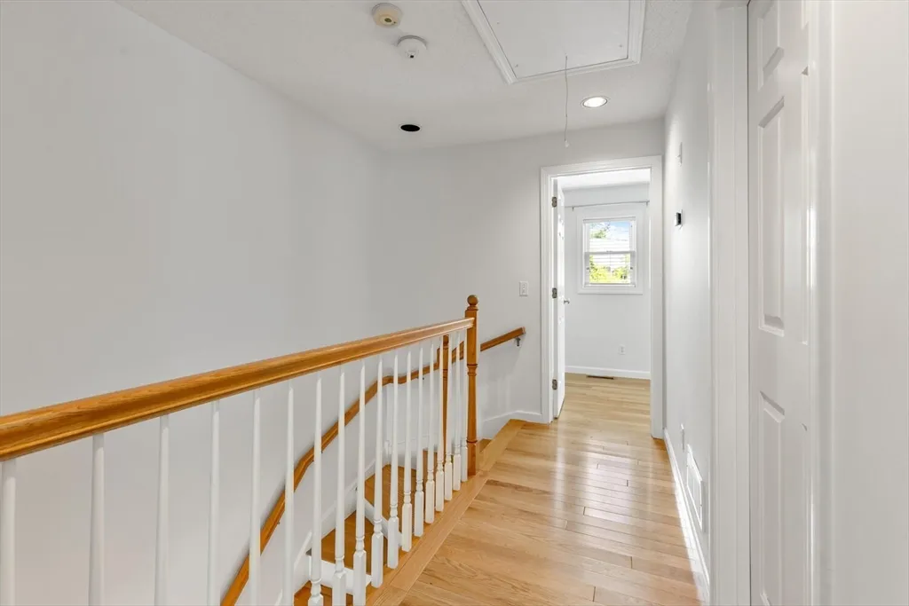 a view of a hallway with wooden floor and staircase