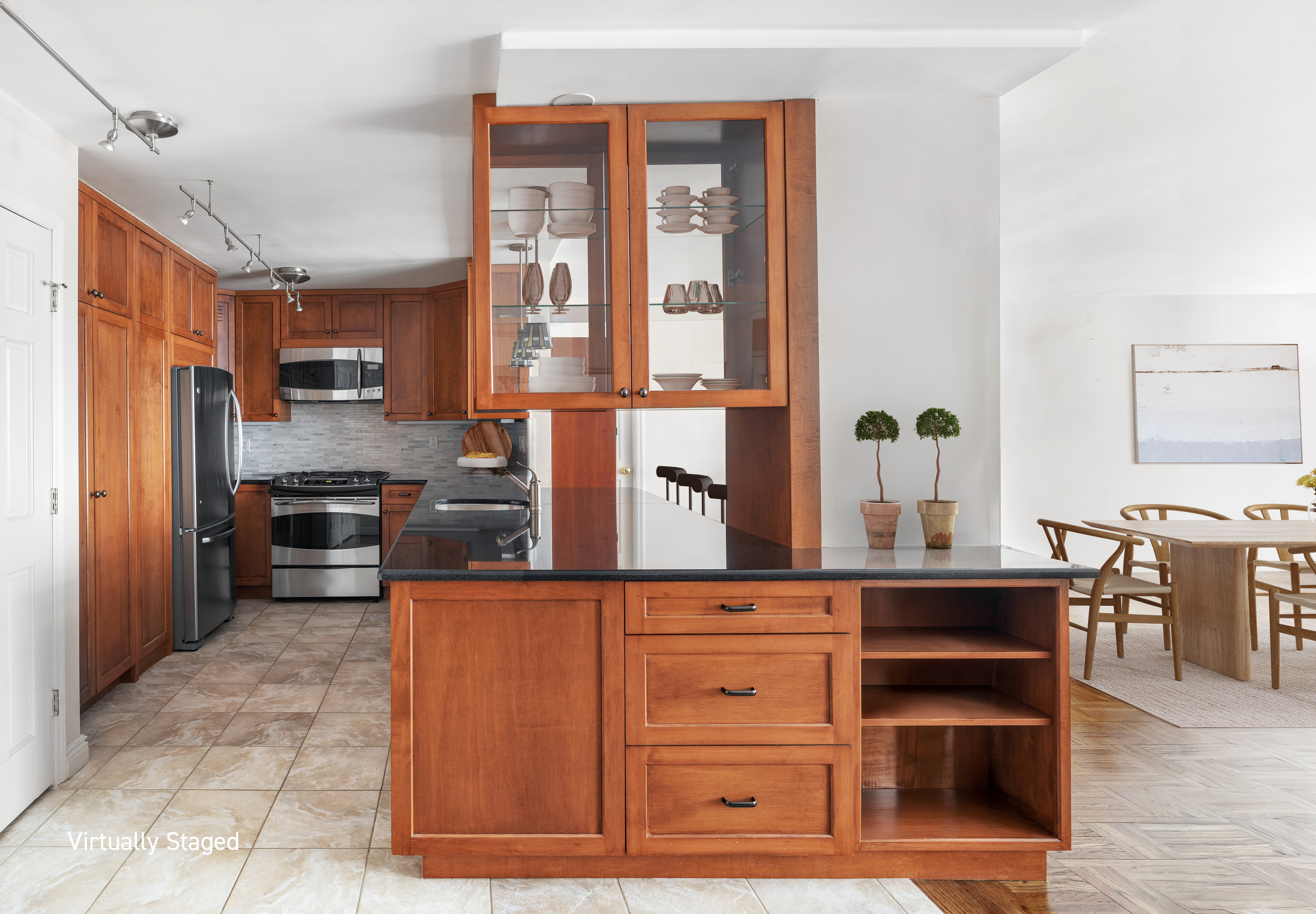 15 West 72nd Street, Unit 8TU Manhattan, NY 10023 - Photo 5 of 12 a kitchen with stainless steel appliances kitchen island granite countertop a refrigerator and cabinets